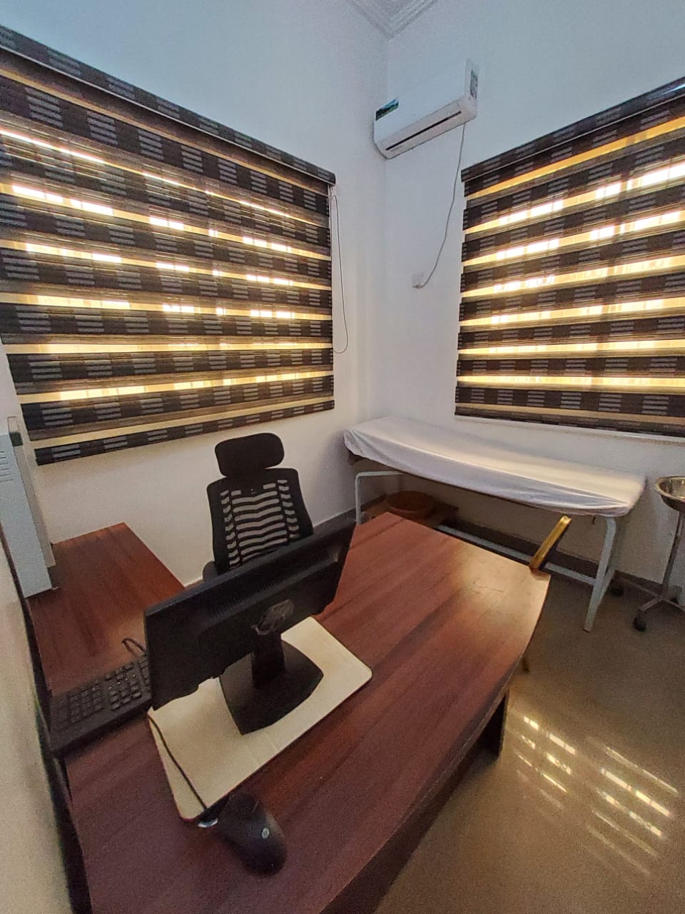 Doctor's consultation room with desk and examination couch